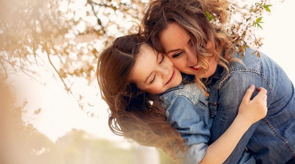 Mother and daughter embrace in nature